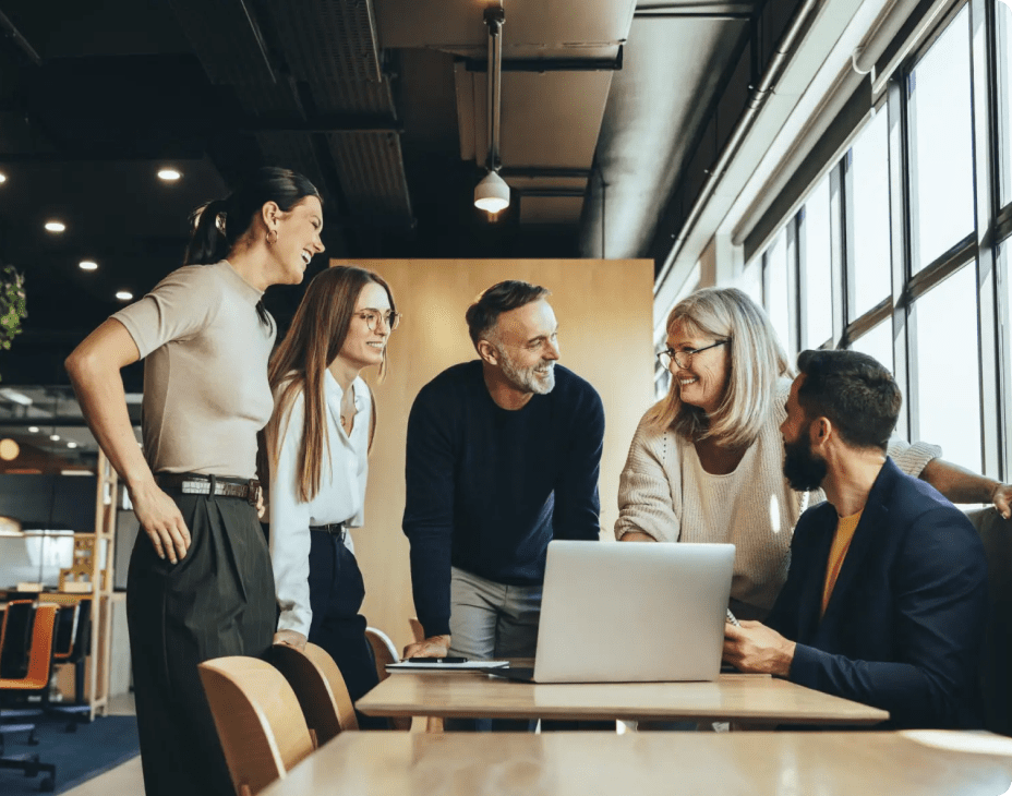 happy business people standing around computer